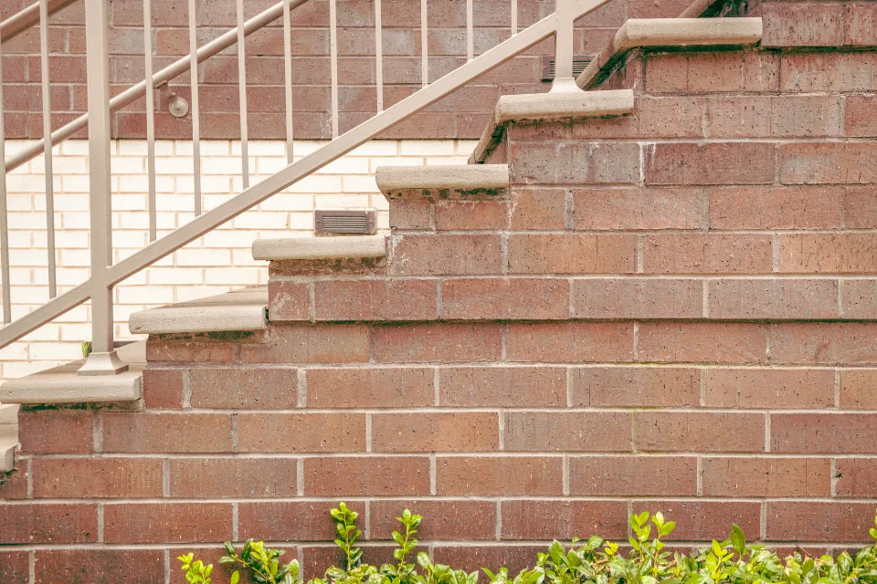 Brick wall and steps with a metal handrail