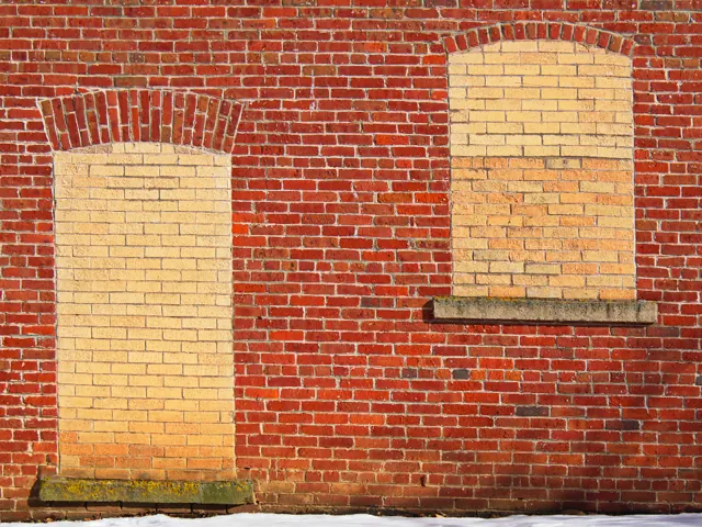 Red brick wall with bricked-up window openings