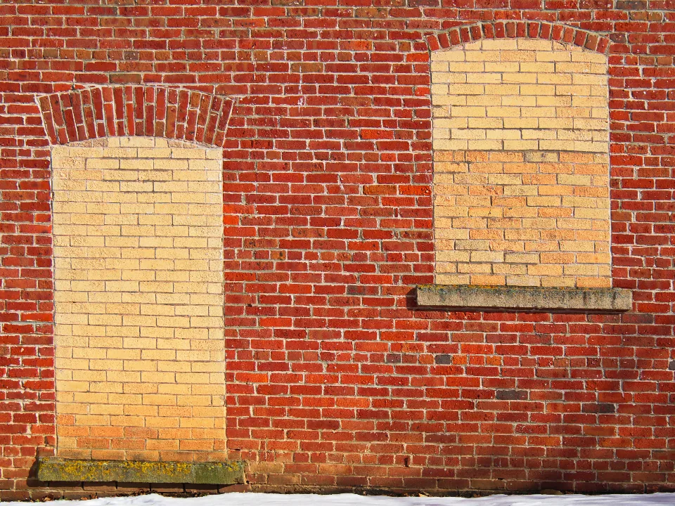 Red brick wall with bricked-up window openings
