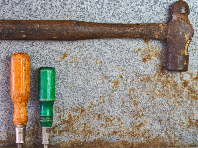 Hammer and screwdrivers on a stone surface