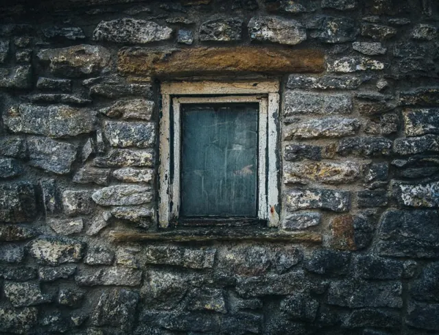 Stone wall with a small window